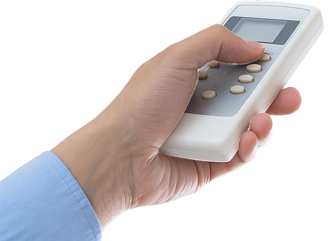 Mano sujetando un mando a distancia para encender aire acondicionado split en vivienda en Valladolid